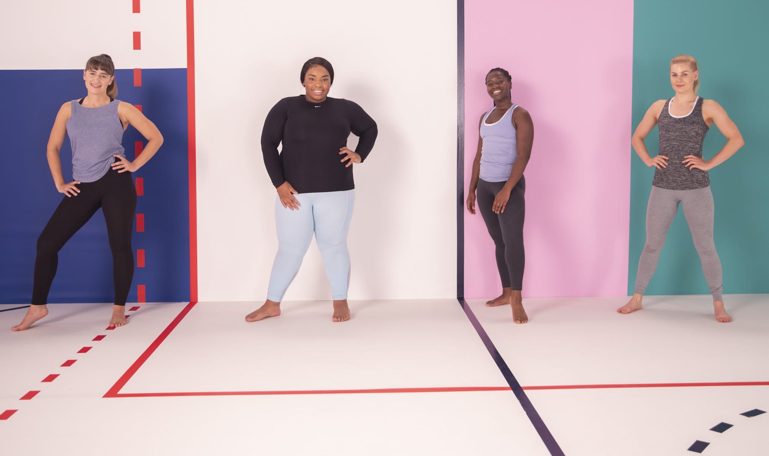 Four women facing the camera in a gym setting