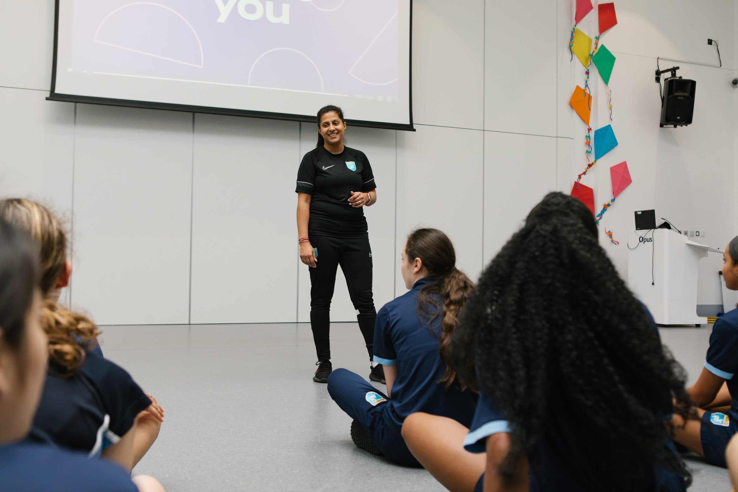 A female teacher speaking to her class within a PE lesson