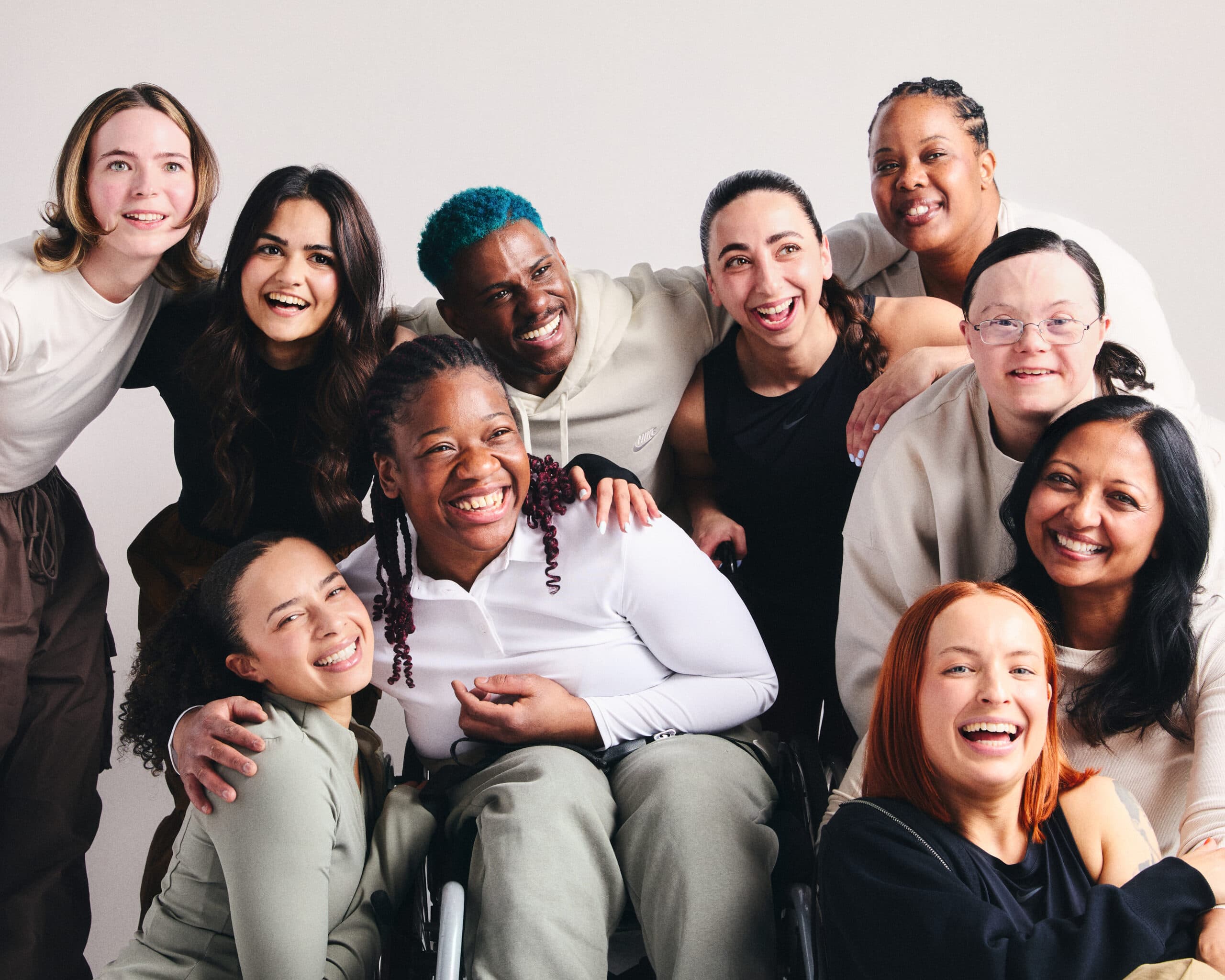 A group picture of all 10 Nike and Disability Sports Coach trainers together, smiling with their arms round each other