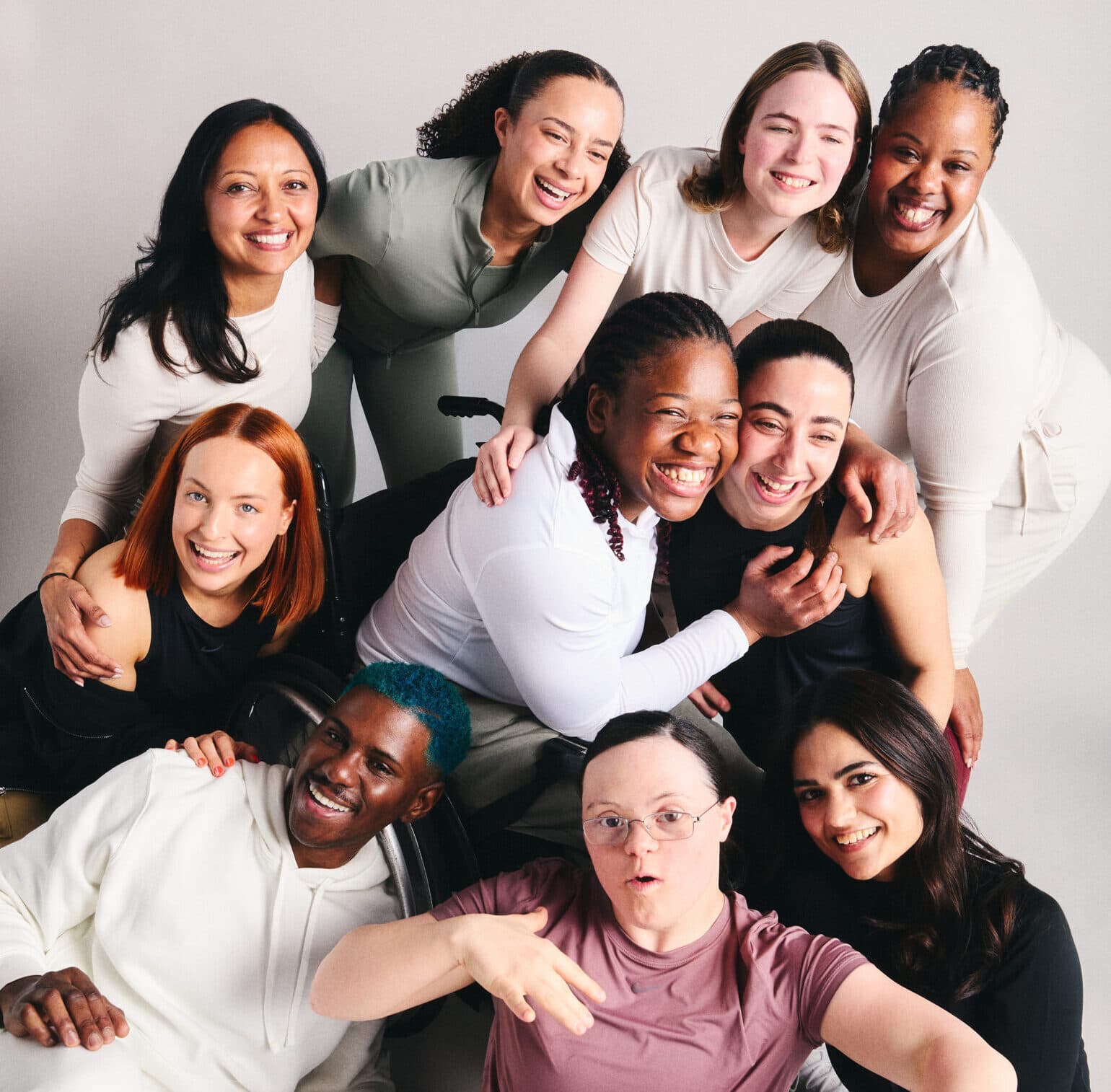 A group picture of all 10 Nike and Disability Sports Coach trainers together, smiling with their arms round each other